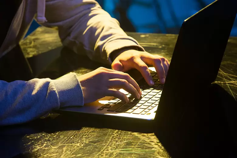 hooded-computer-hacker-stealing-information-with-laptop(1)
